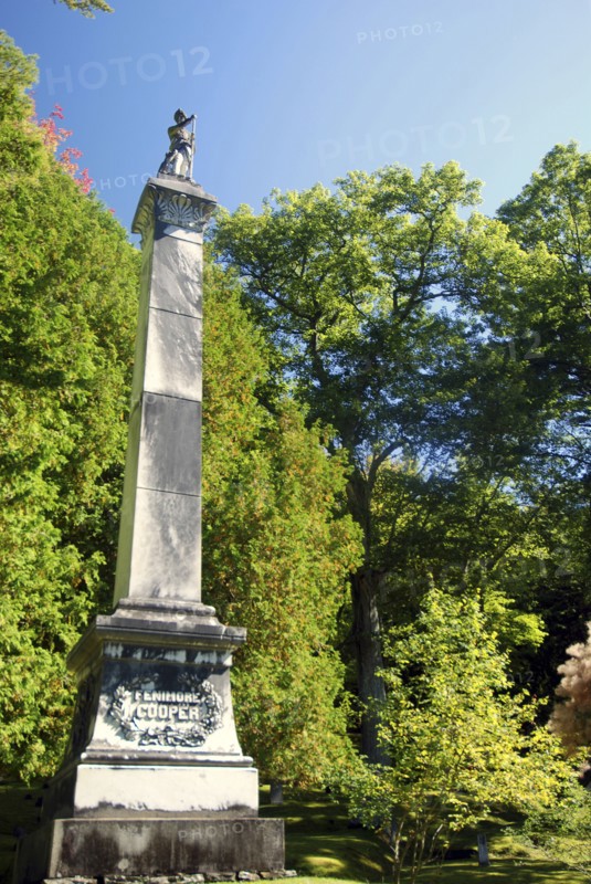 USA, New York State, Cooperstown, "Monument to James Fenimore Cooper topped with statue of Natty Bumpo, hero of ""Leatherstocking Tales"", in local cemetary."