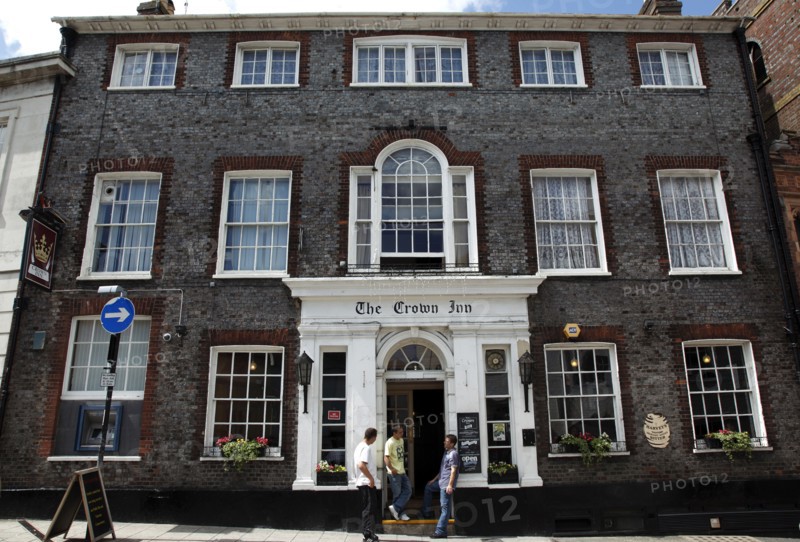ENGLAND, East Sussex, Lewes, "High Street, Crown Inn Hotel and Bar. Featured on hotel inspectors tv programme. Smokers standing outside entrance smoking."