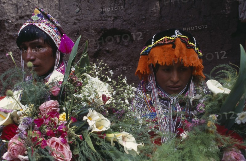 PERU Cusco Pisac Young couple in traditional dress behind flower display during village festival.Cuzco Pisaq American Cusco Peruvian Pisac South America Hispanic Latin America Latino Cuzco Pisaq American Cusco Peruvian Pisac South America Hispanic Latin America Latino