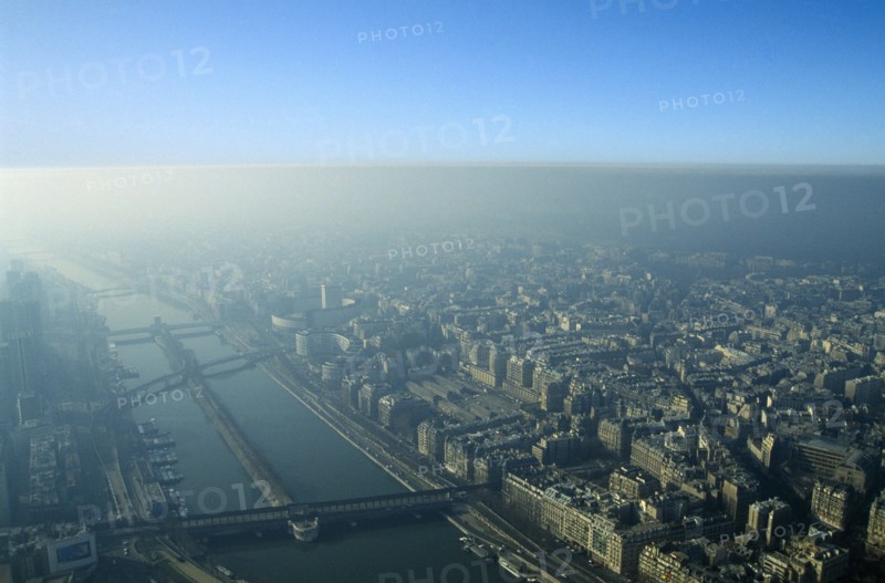 France, Ile de France, Paris, Aerial view over city and river through thick smog.