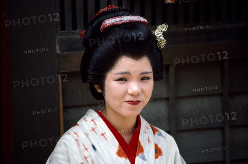 Japan, Honshu, Kyoto, Smiling female actress dressed in traditional costume of a Geisha in the Kyoto Movie Village home of the Samurai movies.