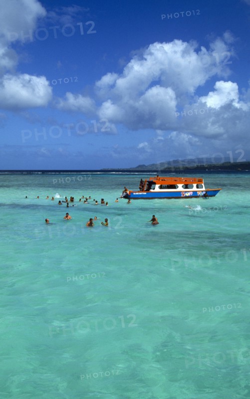 West Indies, Caribbean, Tobago, Tourists swimming in the shallow water beside a glass bottomed boat in the Nylon Pool in Buccoo Reef a coral reef in the marine park.