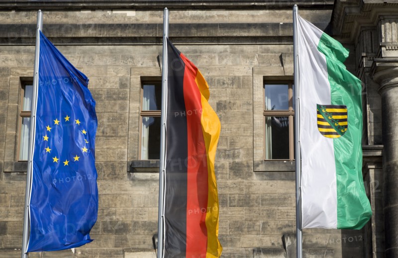 GERMANY, Saxony, Dresden, The flags of the EU European Union, Germany and Saxony flying from flagpoles in front of the Neues Standehaus.