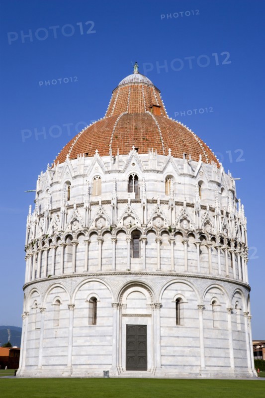ITALY, Tuscany, Pisa, Campo dei Miracoli or Field of Miracles with the Baptistry under a blue sky.
