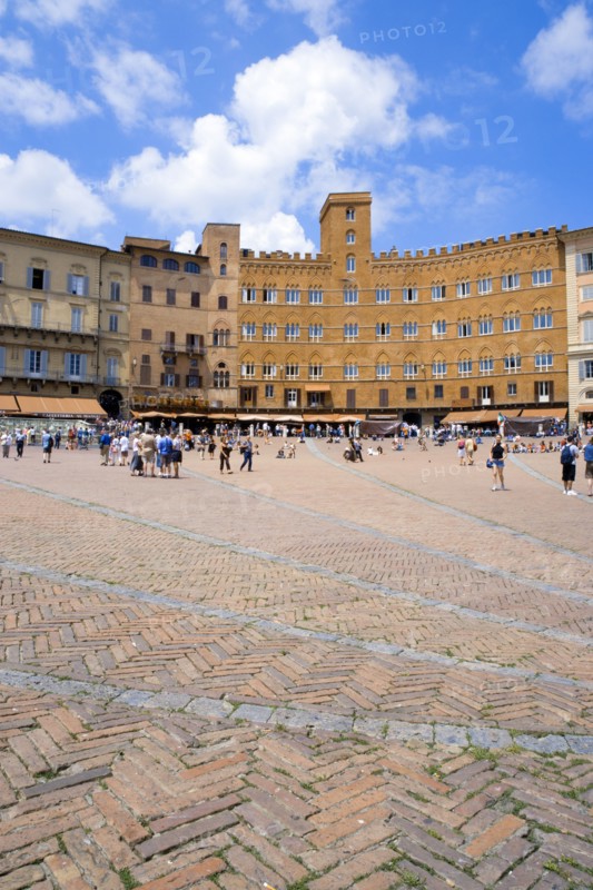 ITALY, Tuscany, Siena, Piazza del Campo and surrounding buildings under a blue sky and busy with tourists.