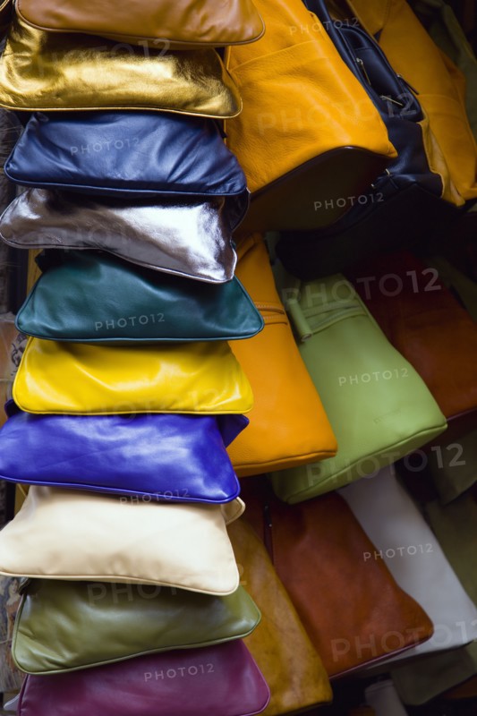 ITALY, Tuscany, San Gimignano, Colourful locally made leather bags displayed in a shop doorway.