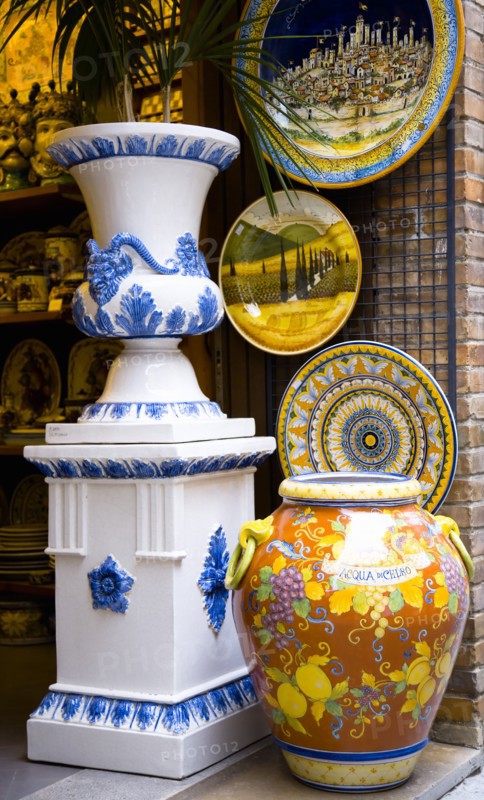 ITALY, Tuscany, San Gimignano, Colourful glazed local ceramics displayed in a shop doorway.