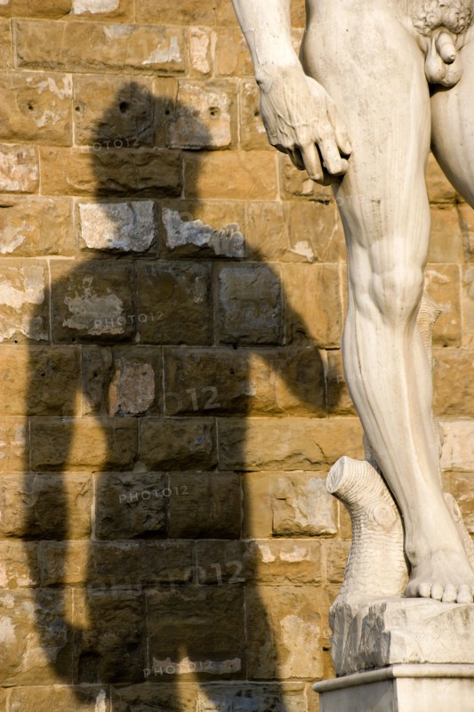 ITALY, Tuscany, Florence, Shadow of the replica Rennaisance statue of David by Michelangelo on the wall of the Palazzo Vecchio in the Piazza della Signoria.