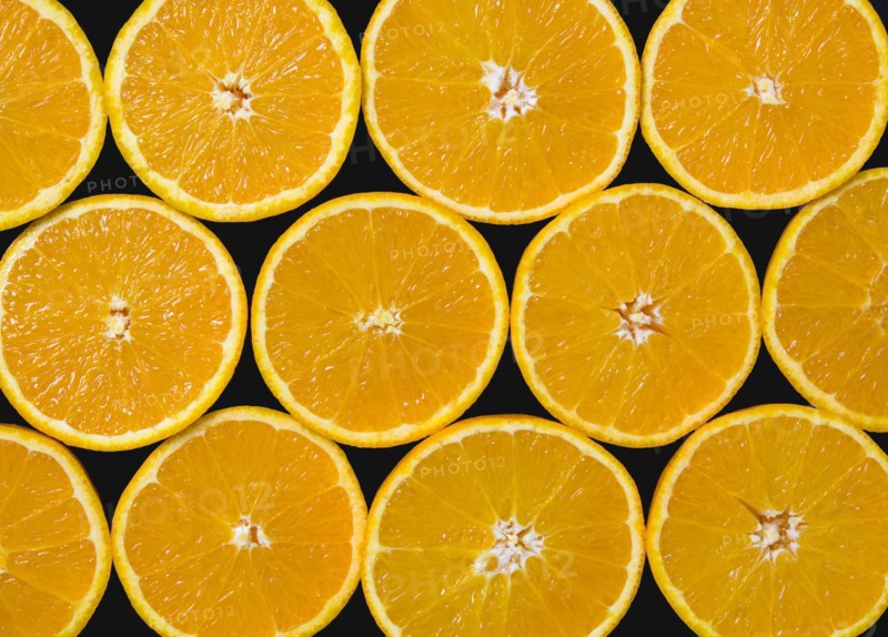 Food, Fruit, Oranges, Overhead view of group of oranges cut in half showing core and segments against a black background.