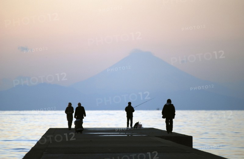 Japan, Honshu, Chiba, Tateyama,  sightseers and fisherman on pier, across Tokyo Bay Mount Fuji visible.