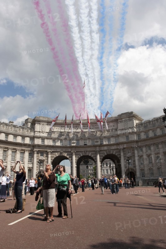 ENGLAND, London, The Mall and Horseguards, Admiralty Arch, People are looking at the colored line trails that were left from flying military aircrafts on formation, as part of Queen of Englandís Elisabeth birthdayís celebration.
