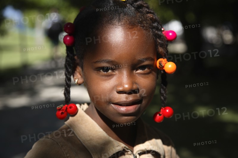 Dominican Republic, Samana Peninsula, Cayo Levantado, Barcardi Island, Portrait of local school girl with coloured beads in her hair.