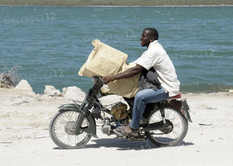 Haiti, Isla de Laganave, Man transporting goods on motorcycle.