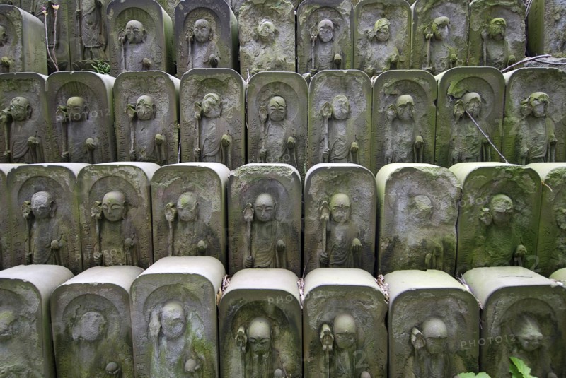 Japan, Tokyo, Nippori, dozens of stone Jizo statues of Buddha at Jomyo-in shrine.