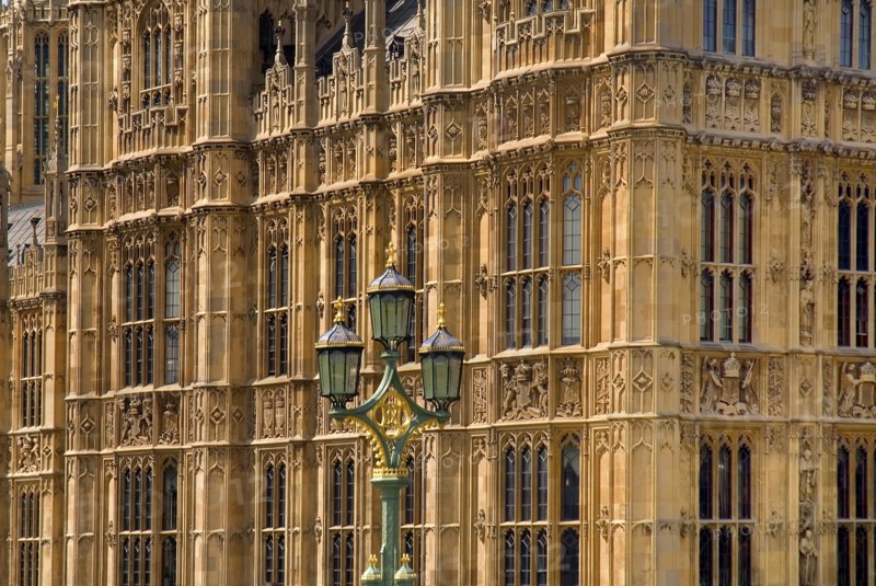England, London, Westminster,  Houses of Parliament, detail of a section of the building with green ornate lamp post in front.