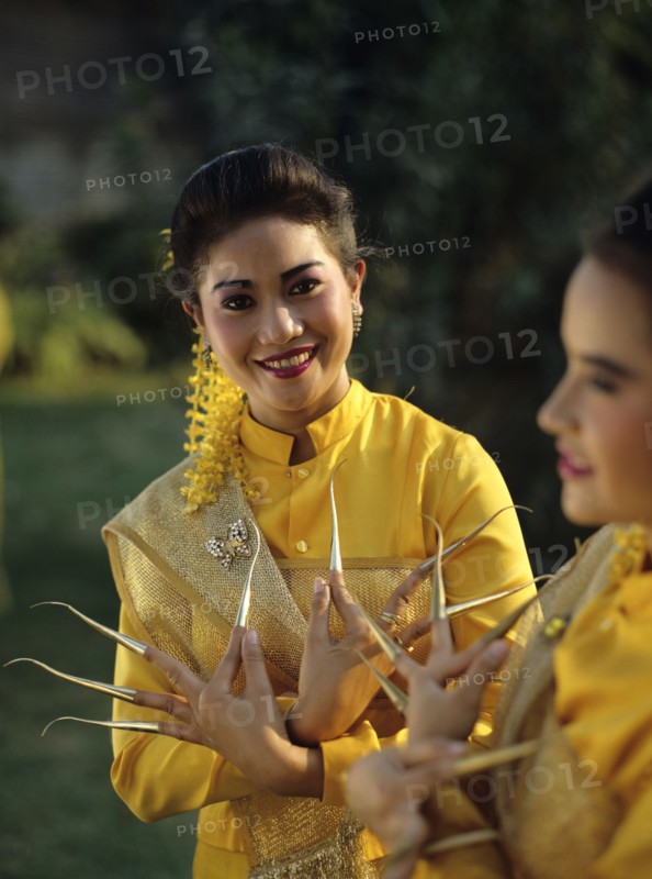 Thailand, women in traditional dress with nail extensions.