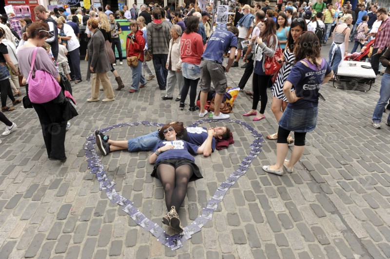 Scotland, Lothian, Edinburgh Fringe Festival of the Arts 2010, Street performers and crowds on the Royal Mile, performers with flyers in shape of heart on ground.