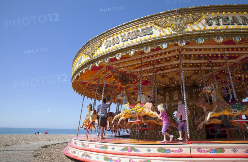England, East Sussex, Brighton, Carousel on the pebble beach promenade.