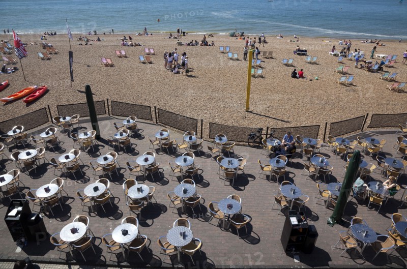 England, East Sussex, Brighton, view over tables outside seafront bar under the promenade.