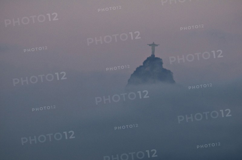 Rio de Janeiro, Brazil. The statue of Christ the Redeemer and the peak of Corcovado mountain above the cloud as dawn breaks over the city. Brazil Brasil Brazilian Brasilian South America Latin Latino American City Travel Destination Urban Vacation Statue Christ Redeemer Corcovado Color Destination Destinations Gray Latin America Religion Religious South America Southern