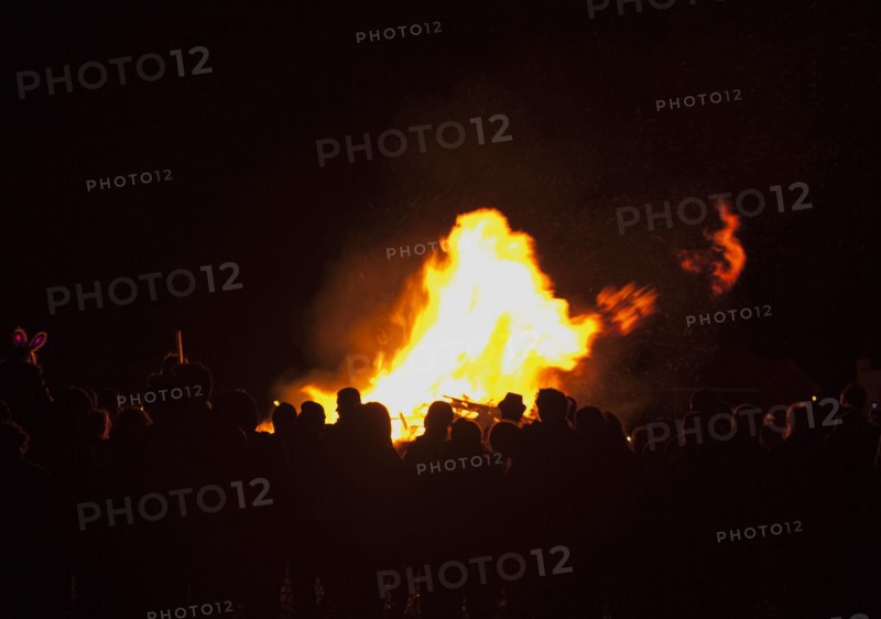 Shoreham Beach, West Sussex, England. Festivals Guy Fawkes Bonfire People silhouetted by flames from fire on the beach. Festival Festivals Bonfire Night Guy Fawkes Flame Flames People Group Crowd Revellers Silhouette Silhouetted Fire Orange Yellow Black