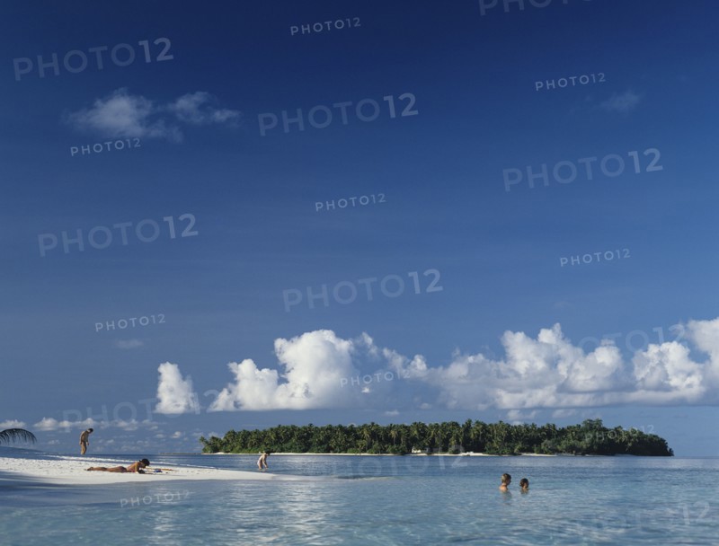 Beach, Maldives. Beach with tourist sunbathing and swimming in the Indian Ocean. Maldives Island Islands Paradise Holiday Sea Water Travel Calm Blue Sky Beach Sand Shore Coast Indian Ocean Asia Asian Palm Trees Clear Vacation Tourists Color Destination Destinations Divehi Rajje Holidaymakers Sand Sandy Beaches Tourism Seaside Shore Tourist Tourists Vacation Sightseeing Sunbather