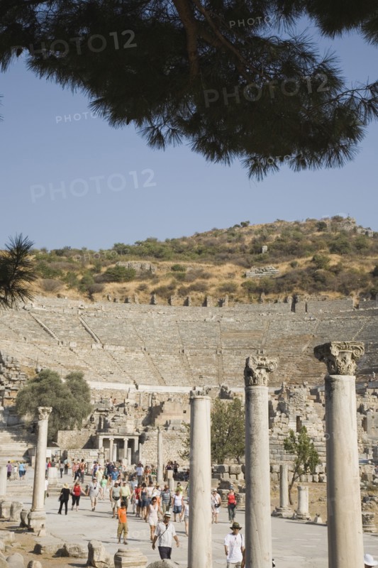 Selcuk, Izmir Province, Turkey. Ephesus. Crowds of tourists visiting ancient city of Ephesus on the Aegean sea coast with amphitheatre part seen behind. Turkey Turkish Eurasia Eurasian Europe Asia Turkiye Izmir Province Selcuk Ephesus Ruin Ruins Masonry Rock Stone Tourists Amphitheater Amphitheatre Destination Destinations European History Historic Holidaymakers Middle East South Eastern Europe Tourism Water Western Asia