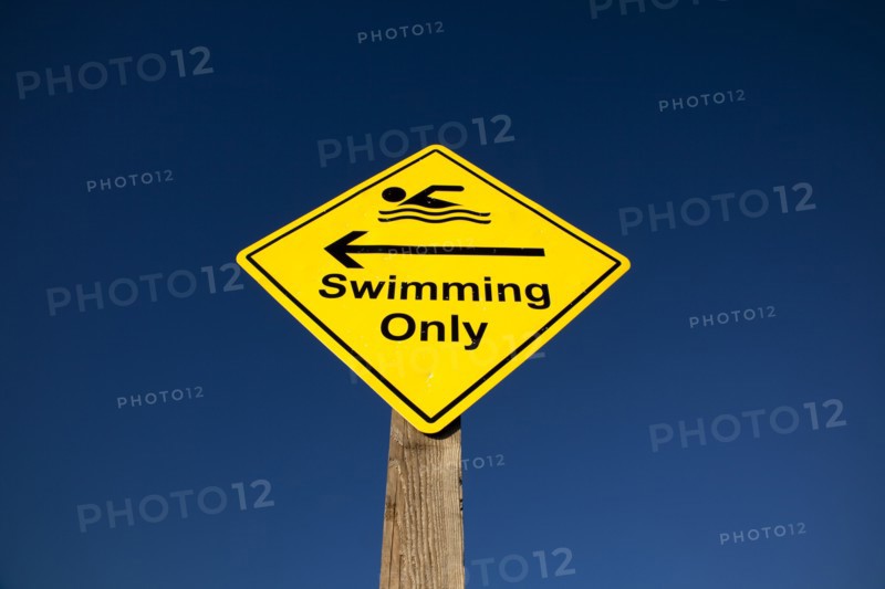 Shoreham-by-Sea, West Sussex, England. Sign indicating stretch of beach suitable for safe swimming. Sign Signs Information Warn Warning Indicate Indicating Safe Safety Yellow Blue Sky Swim Swimming Swimmer Swimmers Show Showing Point Pointing Arrow Post Only