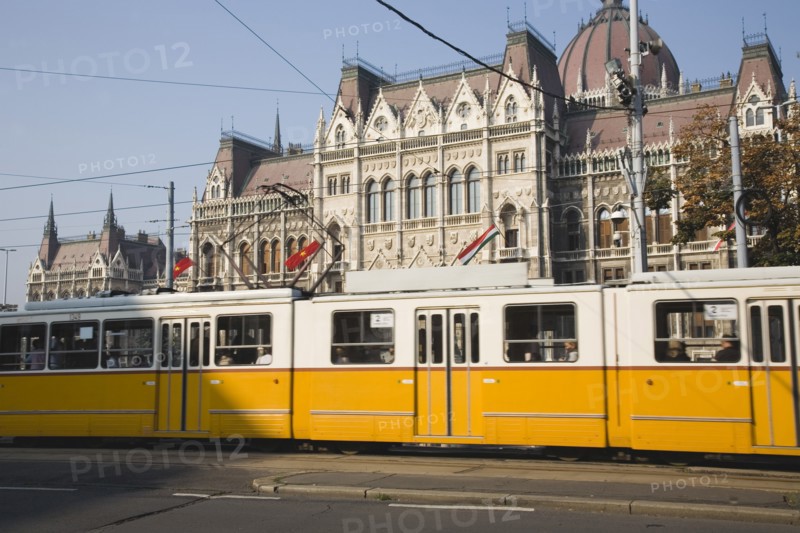 Budapest, Pest County, Hungary. Yellow tram passing the Parliament Building. Hungary Hungarian Europe European East Eastern Buda Pest Budapest City Architecture Building Building Urban Transport Tram Tram Color Destination Destinations Eastern Europe Parliment