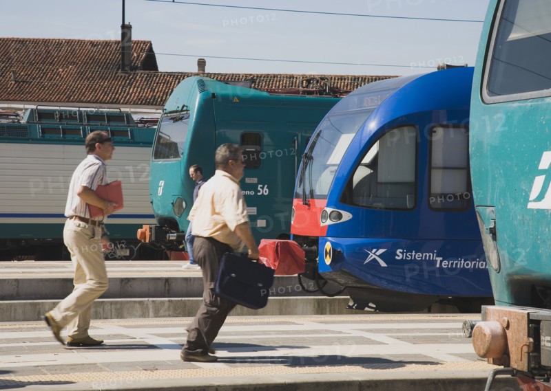 Venice, Veneto, Italy. Commuters running to board local train with regional trains on platforms at side. Italy Italia Italian Venice Veneto Venezia Europe European City Transport Train Trains Rail Railways Communications People Travel Commute Commuters Platform Rush Rushing Hurry Station Destination Destinations Southern Europe