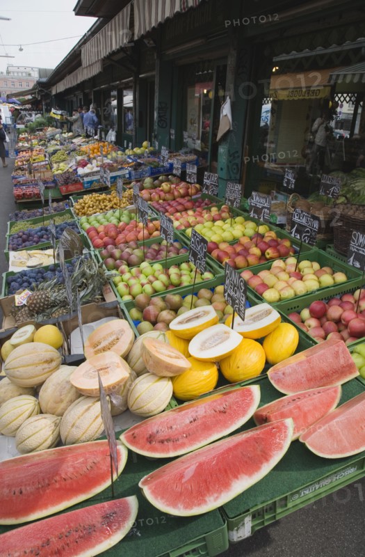 Vienna, Austria. The Naschmarkt. Display of fresh fruit for sale on stall outside shopfront including apples melon and pineapple. Austria Austrian Republic Vienna Viennese Wien Europe European City Capital Naschmarkt Market Display Fresh Food Fruit Vegetables Veg Vegetable Stall Shop Store Destination Destinations Osterreich Viena Western Europe
