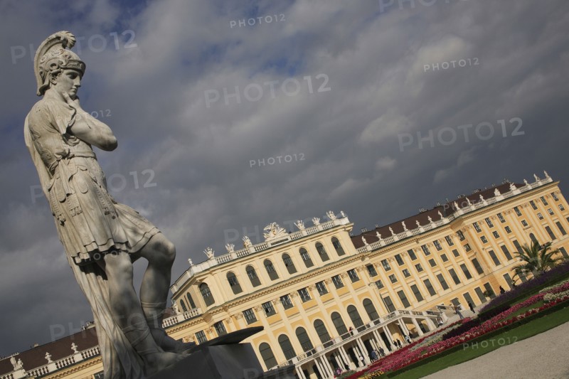 Vienna, Austria. Roman statue in the gardens of the Schonbrunn Palace Austria Austrian Vienna Wien Viennese Republic Austro-Bavarian Wean Europe European City Capital Exterior Travel Destination SchonnBrunn Schonbrunn Schloss Palace Architecture Art Imperial Summer Residence UNESCO World Heritage Site Beautifu Spring Blue Clouds Cloud Sky Destination Destinations Garden Plants Flora Gray History Historic Osterreich Viena Western Europe