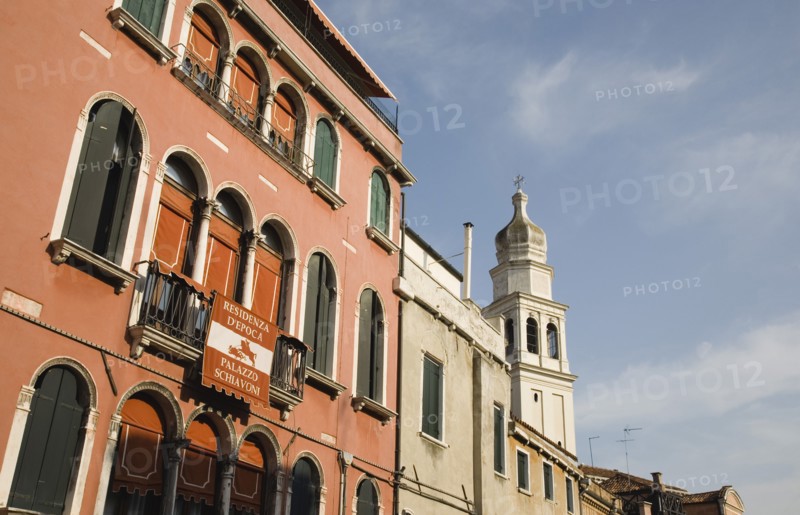 Venice, Veneto, Italy. Centro Storico Restored facade of building painted a terracotta colour with multiple arched windows in late summer sun. Italy Italia Italian Venice Veneto Venezia Europe European City Centro Storico Facade Facade Terracotta Red Arch Arches Arched Window Windows Restored Restoration Palace Palazzo Schivoni Color Destination Destinations Southern Europe