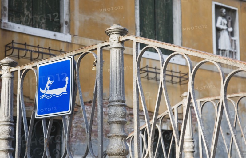 Venice, Veneto, Italy. Centro Storico Gondola access via iron stairway indicated with tourist sign in blue and white. Italy Italia Italian Venice Veneto Venezia Europe European City Centro Storico Sign Bridge Wrought Iron Rail Railings Gondola Blue Destination Destinations Sightseeing Signs Display Posted Signage Southern Europe Tourists