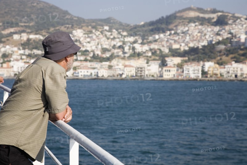 Samos, Northern Aegean, Greece. Vathy. Tourist rests on handrail on deck of ferry between Samos and Kusadasi in Turkey as it leaves Vathy Samos. Greece Greek Europe European Vacation Holiday Holidays Travel Destination Tourism Ellas Hellenic Northern Aegean Samos Island Vathy Tourist Travel Transport Ferry Boat Ship Water Sea Destination Destinations Ellada Holidaymakers Middle East One individual Solo Lone Solitary Sightseeing South Eastern Europe Southern Europe Tourists Turkish Turkiye Water Western Asia