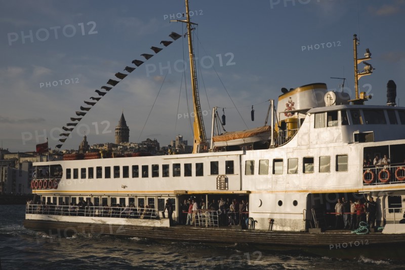 Istanbul, Turkey. Sultanahmet. Crowded ferry flying Turkish flag on the Bosphorous with city behind. Since March 2006 Istanbuls traditional commuter ferries have been operated by Istanbul Sea Buses. Turkey Turkish Istanbul Constantinople Stamboul Stambul City Europe European Asia Asian East West Urban Sultanahmet Bosphorous Destination Travel Tourism Transport Water Ship Boat Ferry Commuter Cummuters Classic Classical Destination Destinations Historical Middle East Older South Eastern Europe Turkiye Water Western Asia