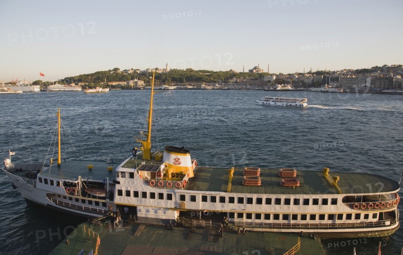 Istanbul, Turkey. Sultanahmet. Bosphorous passenger ferry moored at sunset with the Hagia Sophia behind. Turkey Turkish Istanbul Constantinople Stamboul Stambul City Europe European Asia Asian East West Urban Destination Travel Tourism Sultanahmet Bosphorous Passenger Passengers Ferry Boat Ship Transport Water Sea Commute Commuters Hagia Sophia Mosque Destination Destinations Middle East South Eastern Europe Sundown Atmospheric Turkiye Water Western Asia