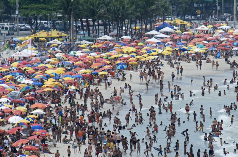 Rio de Janeiro, Brazil. Copacabana beach. Crowds on the beach and in the sea bikinis and multi-coloured beach umbrellas. Brazil Brasil Brazilian Brasilian South America Latin Latino American City Travel Destination Urban Vacation Beach Beaches People Sunbathing Crowds Rio de Janeiro Copacabana Umbrellas Parasols Destination Destinations Holidaymakers Latin America Sand Sandy Beach Tourism Seaside Shore Tourist Tourists Vacation Sand Sandy Beaches Tourism Seaside Shore Tourist Tourists Vacation South America Southern Sunbather Water