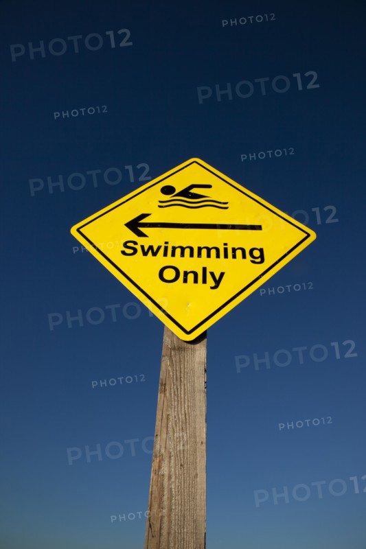 Shoreham-by-Sea, West Sussex, England. Sign indicating stretch of beach suitable for safe swimming. Sign Signs Information Warn Warning Indicate Indicating Safe Safety Yellow Blue Sky Swim Swimming Swimmer Swimmers Show Showing Point Pointing Arrow Post Only