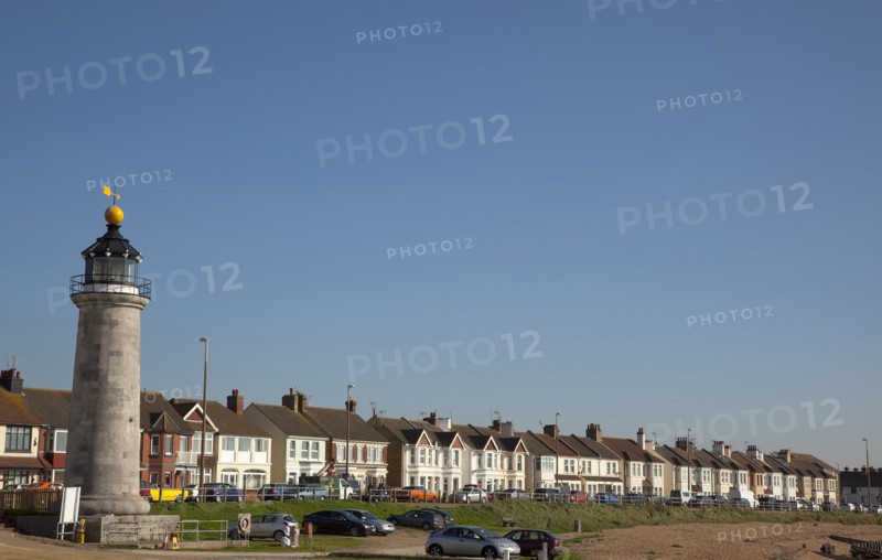 Shoreham-by-Sea, West Sussex, England. Kingston Beach Lighthouse and residential housing along Brighton Road. England English UK United Kingdom GB Great Britain Europe European West Sussex County Shoreham Shoreham-by-Sea By Sea Kingston Beach Light House Lighthouse Warning Beacon Architecture Housing Residential Homes Houses Traffic Blue Sky