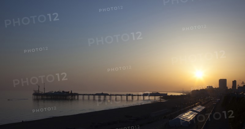 Brighton, East Sussex, England. View of the pier at sunset from the seafront promenade in Kemptown. England English UK United Kingdom United Kingdom GB Great Great Britain Britain British Europe European East Sussex East Sussex County Brighton Kemptown Marine Parade Sea Seafront Promenade Pier Sunet Blue Sky Illuminated Lit up Travel Silhouette Silhouetted
