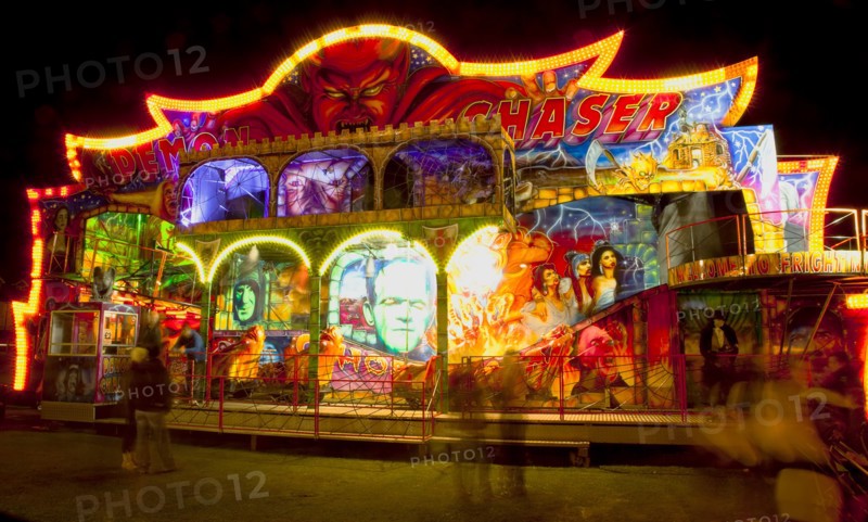 Lancing, West Sussex, England. Entertainment Funfairs Rides illuminated at night. England English UK United Kingdom GB Great Britain British Europe European West Sussex Lancing Funfair Rides Night Entertainment Leisure Color Colour Colorful Colourful Colored Coloured People Crowd Blur Blurred Ferris Wheel Big Neon Light