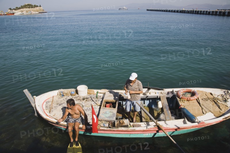 Kusadasi, Aydin Province, Turkey. Local fisherman in fishing boat with family member preparing to dive for mussels. Turkey Turkish Eurasia Eurasian Europe Asia Turkiye Aaydin Province Kusadasi Fishing Fisherman Fishermen Boat Dive Diver Diving Mussels Men Man Male Water Sea Destination Destinations European Male Man Guy Male Men Guy Middle East South Eastern Europe Water Western Asia