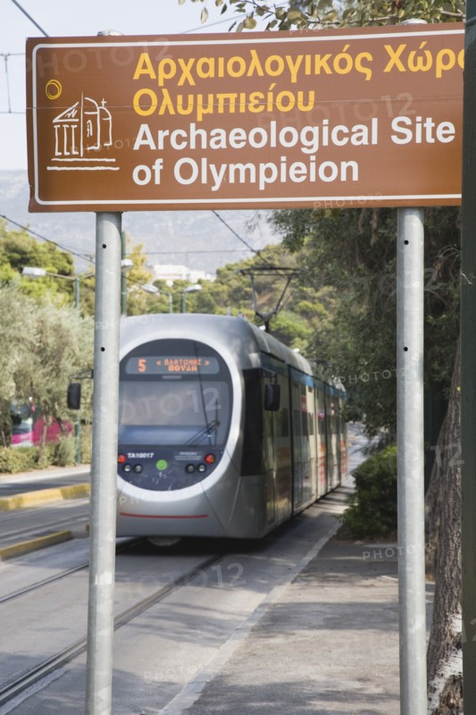 Athens, Attica, Greece. Modern tram adjacent to The Temple of Olympian Zeus with tourist heritage sign in foreground. Greece Greek Attica Athens Europe European Vacation Holiday Holidays Travel Destination Tourism Ellas Hellenic Temple Olympian Zeus Ruin Ruins Column Columns Sign Tram Olympieion Archaeology Atenas Athenes Destination Destinations Ellada Sightseeing Signs Display Posted Signage Southern Europe Tourists