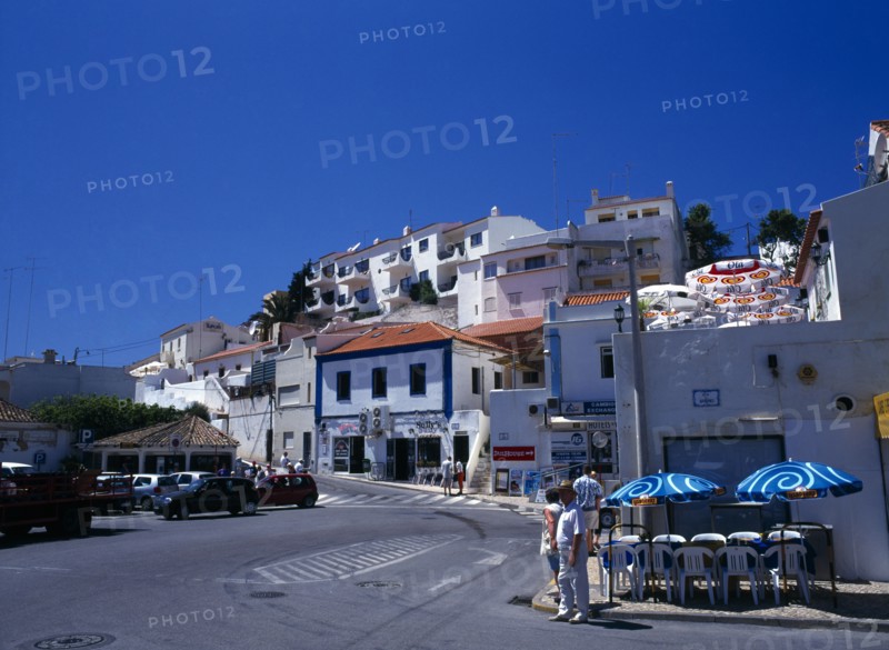Carvoeiro, Algarve, Portugal. Typical street with white washed buildings tourists and traffic Holidaymakers Portuguese Southern Europe Tourism