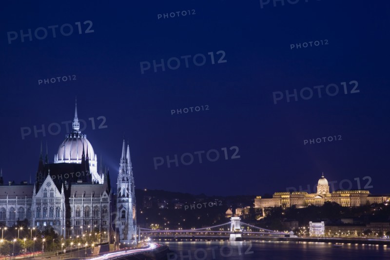 Budapest, Hungary. View along the River Danube at night with the Parliament building on the left the Chain Bridge and the Royal Palace on the right all illuminated brightly. Hungary Hungarian Europe European East Eastern City Cityscape Skyline Night Nighttime Dark Lights Lit Illuminated River Danube Parliament Royal Palace Chain Bridge Travel Destination Holiday Vacation Break Buda Pest Budapest Citiscape Building Buildings Urban Architecture Destination Destinations Eastern Europe Nite Parliment