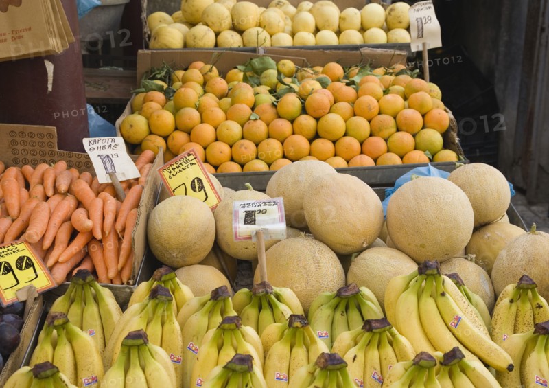 Athens, Attica, Greece. Central Market. Fruit and vegetable summer produce for sale on grocers stall including melons bananas and carrots. Atenas Athenes Destination Destinations Ellada European Greek Southern Europe