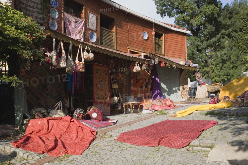 Istanbul, Turkey. Sultanahmet. Textiles and souvenirs displayed for sale next to Hagia Sophia. Turkey Turkish Istanbul Constantinople Stamboul Stambul City Europe European Asia Asian East West Urban Destination Travel Tourism Sultanahmet Textiles Cloth Display Displayed MArket Shop Store For Sale Red Destination Destinations Middle East South Eastern Europe Turkiye Western Asia