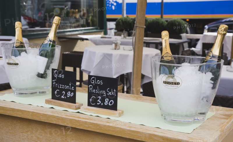 Vienna, Austria. The Naschmarkt Ice buckets with bottles of sparkling Riesling on side table in upmarket outdoor restaurant. Austria Austrian Republic Vienna Viennese Wien Europe European City Capital Naschmarkt Market Cafe Restaurant Bottle Buckets Ice Sparkling Wine Reisling Tables Alcohol Bar Bistro Destination Destinations Osterreich Viena Vino Vin Alcohol Grape Winery Drink Western Europe