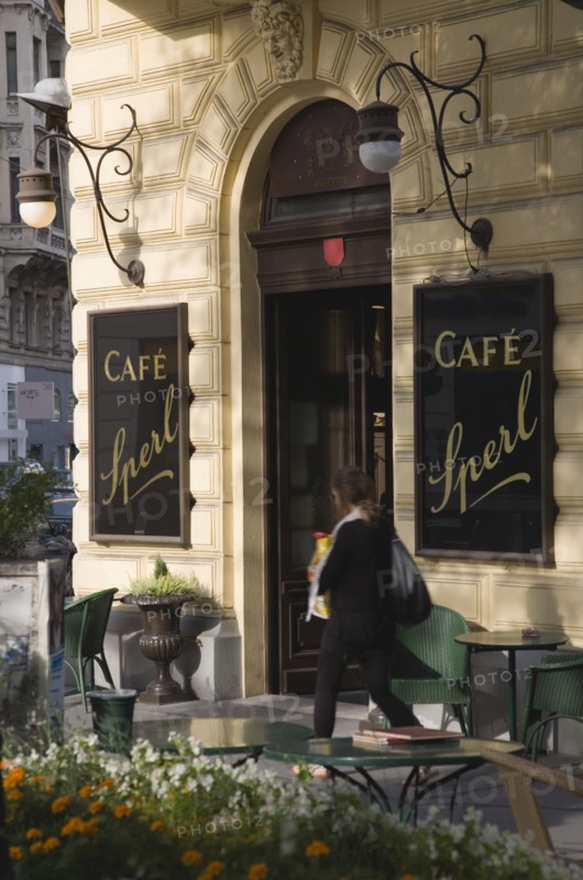 Vienna, Austria. Mariahilf District Cafe Sperl the preferred cafe of Adolf Hitler. Exterior with empty outside tables and woman passing entrance carrying bags. Established for over 120 years the Cafe Sperl offers billiards and forbids mobile phone use. Austria Asutrian Vienna Viennese Mariahlf 6th District Cafe Sperl Hitler Waitress Entrance Coffee Exterior Europe European Work Urban City Table Tables Schanigarten Austrian Bar Bistro Cell Cellular Destination Destinations Female Women Girl Lady History Historic One individual Solo Lone Solitary Osterreich Restaurant Viena Western Europe Wien